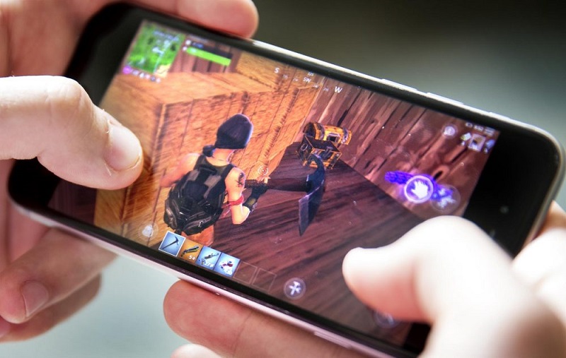 An image showing a person’s hands playing a mobile game