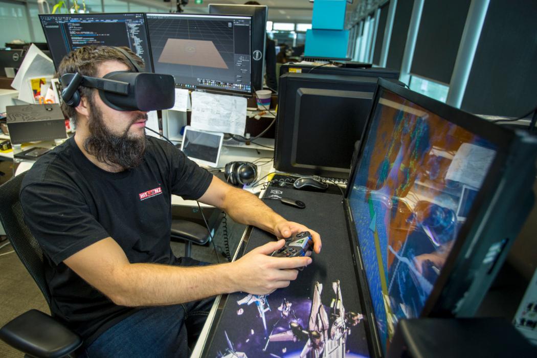 An Image of a Man with virtual reality glasses and playing video game.