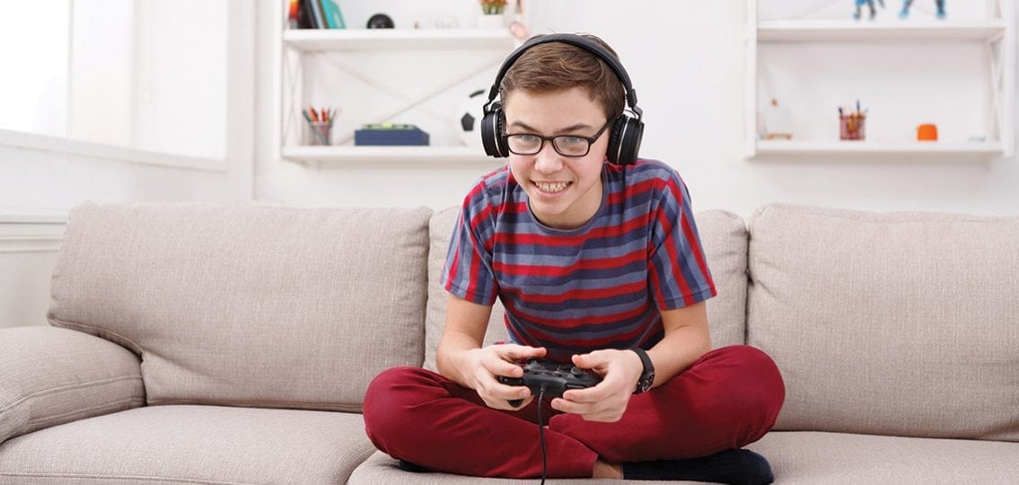 A Smiling and Cheerful Little boy playing videogames.