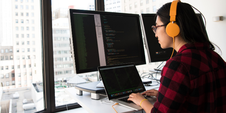 An Image showing a woman performing the code infront of the screen.